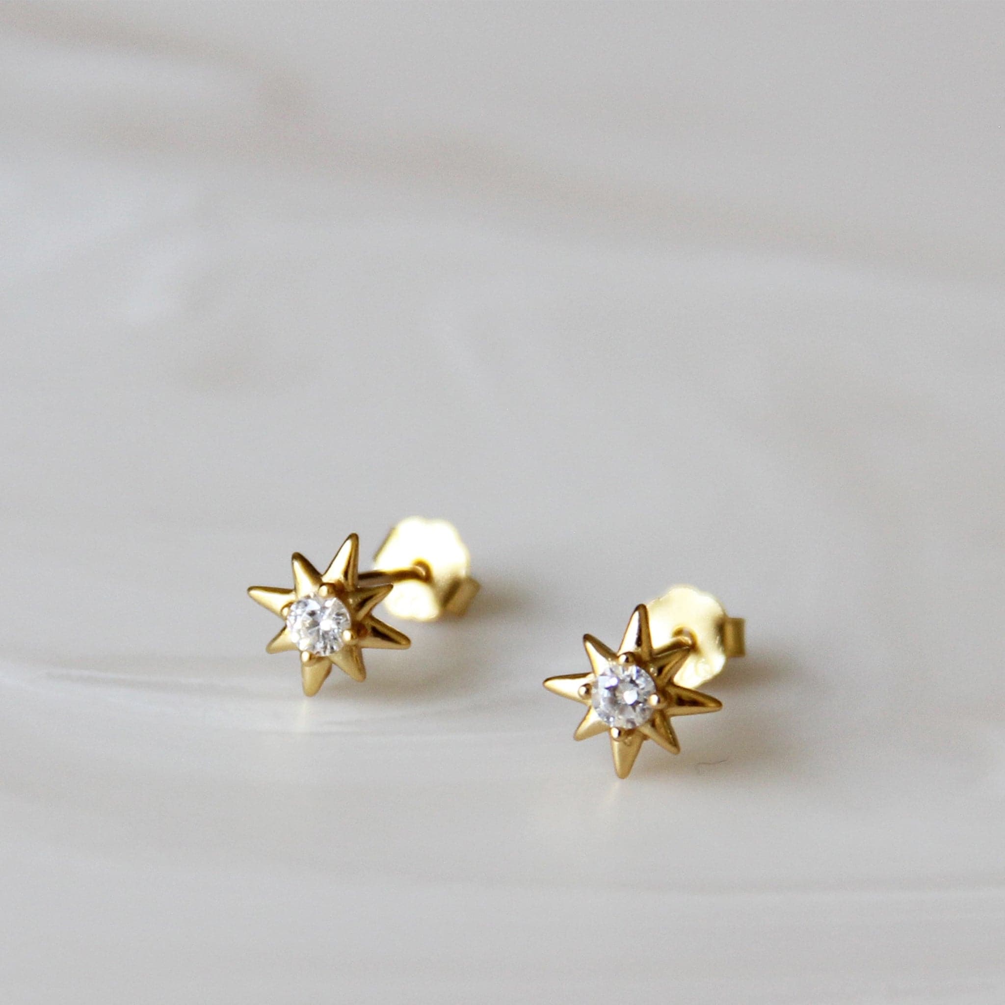 Stud earrings with a 8-point star shape and cz stone in the center.