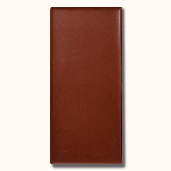 A rectangular bar of milk chocolate photographed on a white background.