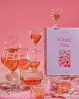 A lavender colored puzzle box that reads, "Cloud Nine" with a photo of what the puzzle looks like. The completed puzzle is a photo of an assortment of drinking glasses filled with a pink drink.