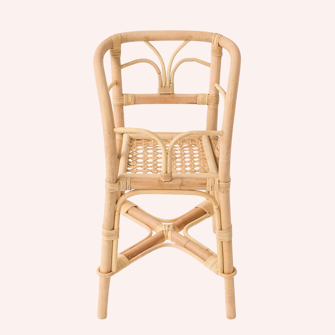 In front of a white background is a light tan wicker high chair. It has four legs. The chair has high arched sides and a back. The bottom of the seat is light tan cane.