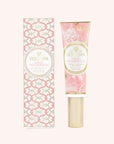 A tube of hand cream decorated with a pink floral pattern with gold text in the center that reads, "Voluspa Saijo Persimmon". The tube of hand cream has a gold pump and gold cap. It comes in a decorative box with a pink and gold woven pattern.