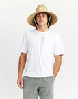 A wide brim sun set made of a neutral woven straw material with a white drawstring and tangerine orange detailing around the edge of the brim as well as the label in the center or the hat.