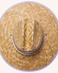 A woven straw sun set with a wide brim, a light purple drawstring and purple detailing underneath the brim of the hat as well as on the center label.