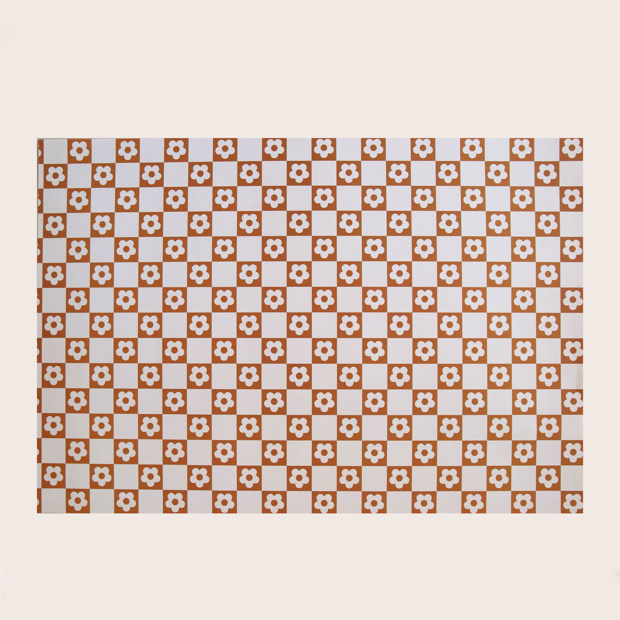 Wrapping paper with a pink and brown flower and checker print all over. 