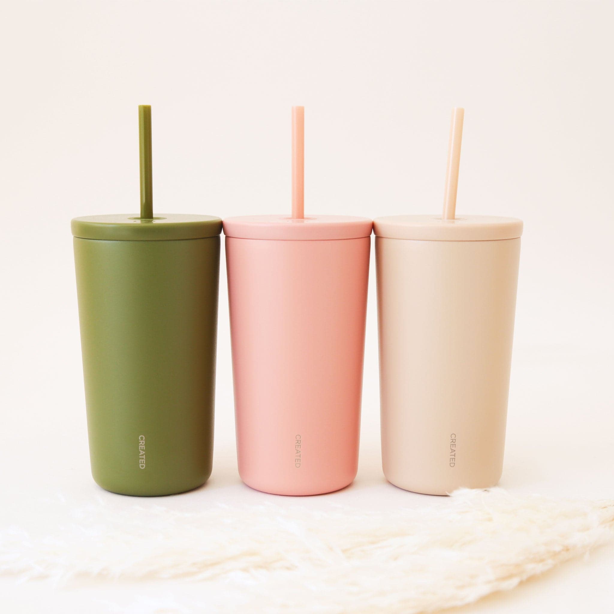 The cold cup next to the other color ways available on our website in a light pink and a green shade. 