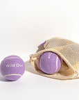 Purple tennis balls that read, "Wild One" in white text.