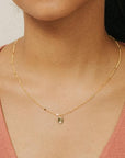 A dainty gold chain with a small circle pendant.