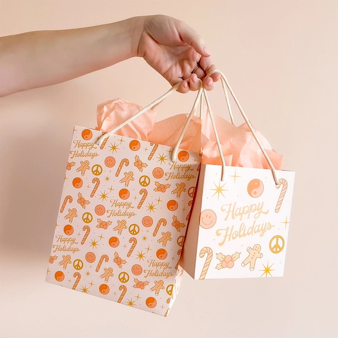 a gift wrapped in paper illustrated with a retro RV camper, a yellow VW Bus, a yellow VW bug and palm trees laying on a wrapping paper with white retro starbursts on a yellow background