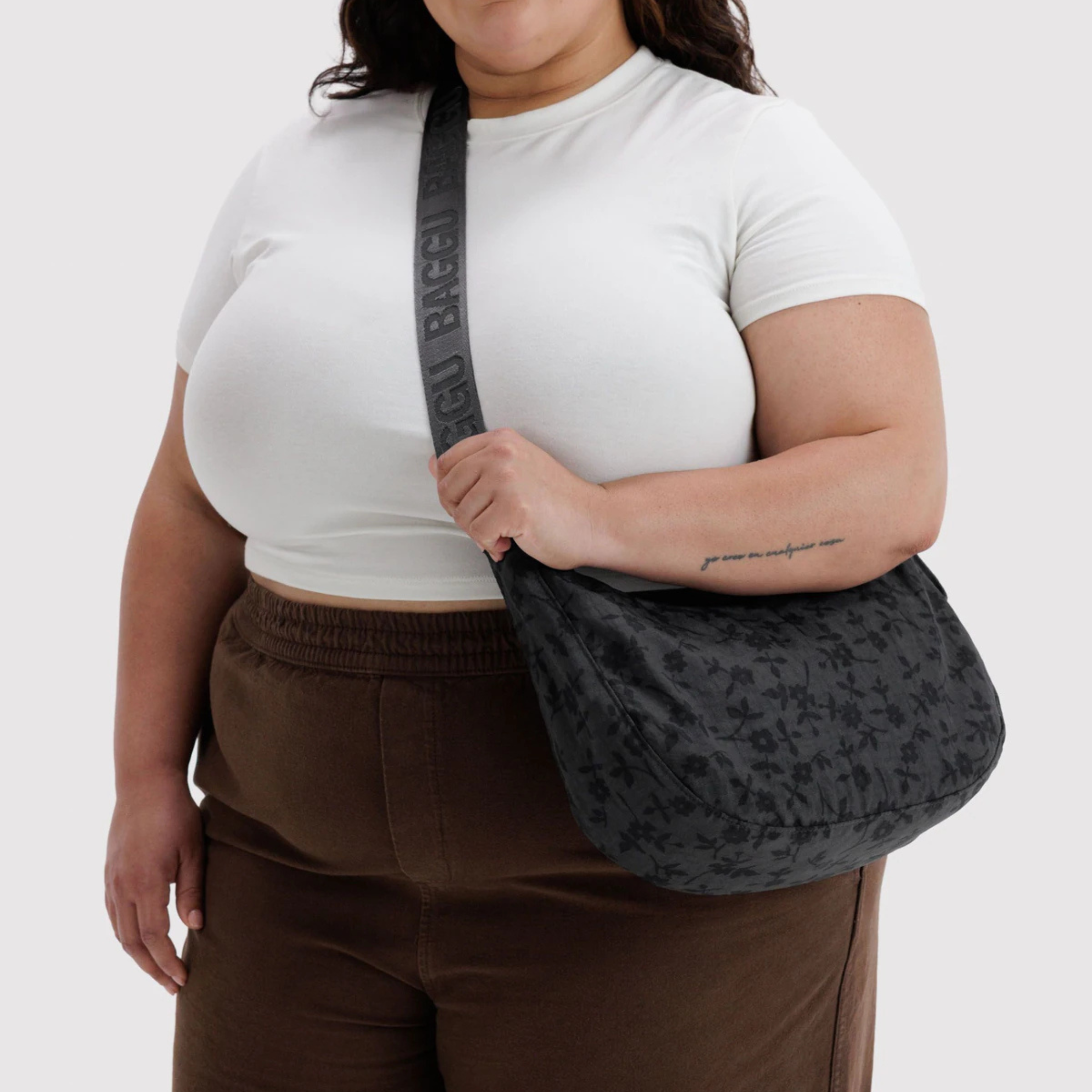 A charcoal crescent bag with a black floral print.