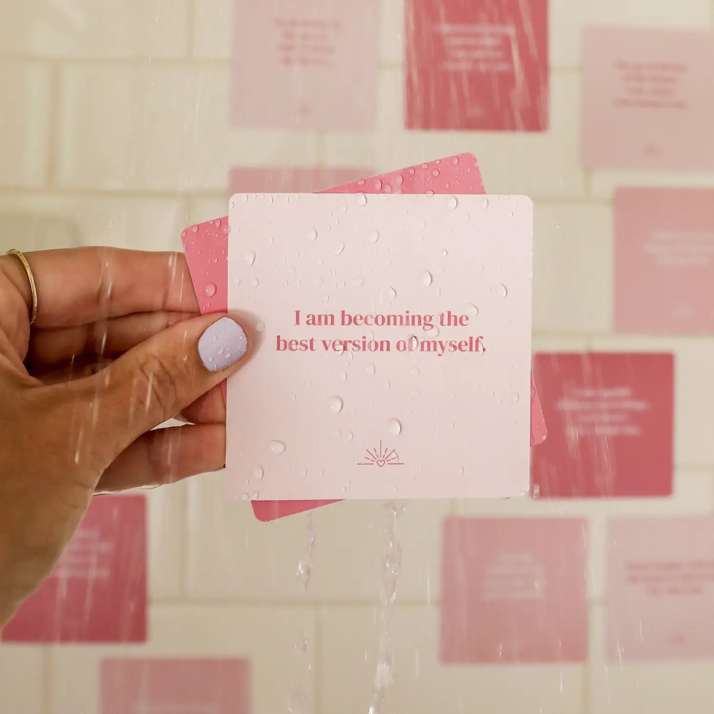 Different tones of pink cards that each have an uplifting affirmation on them for you to read and stick on the walls of your shower.