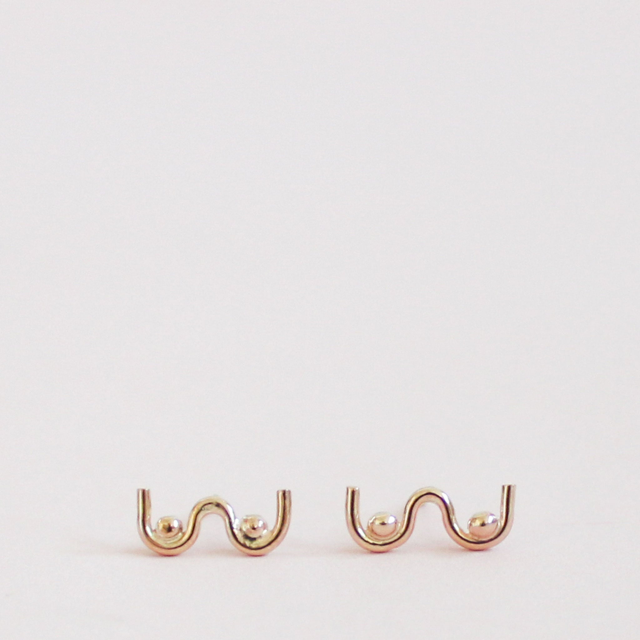 old pair of boob shaped stud earrings