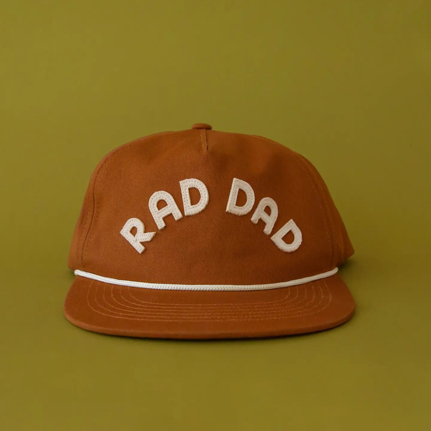 A five panel brown hat with a cream embroidered text that reads, "Rad Dad".