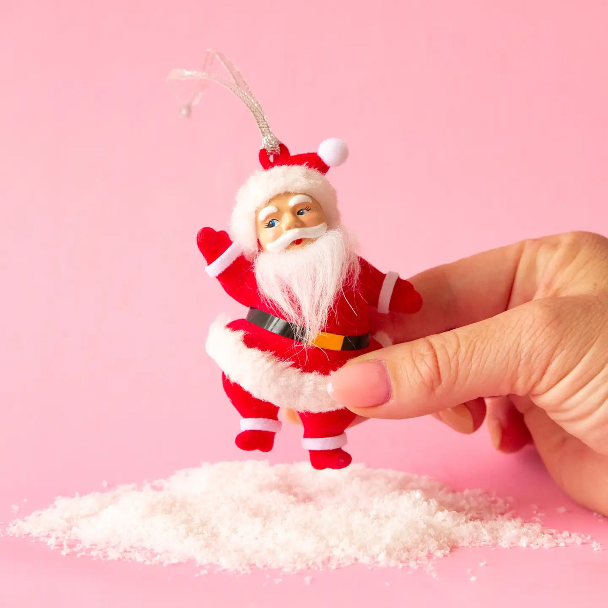 A santa ornament in a bright red velvet suit.