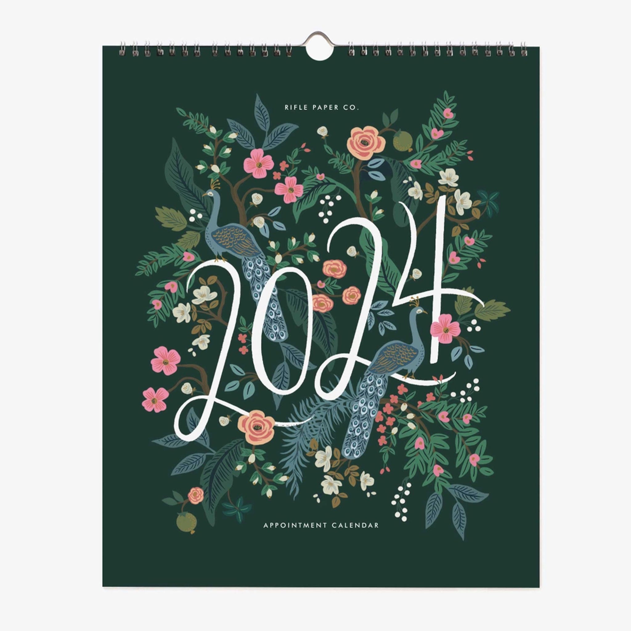 On a white background is a dark green calendar, spiral bound with text on the front that reads, "2024 Appointment Calendar" along with graphics of peacocks and florals. 