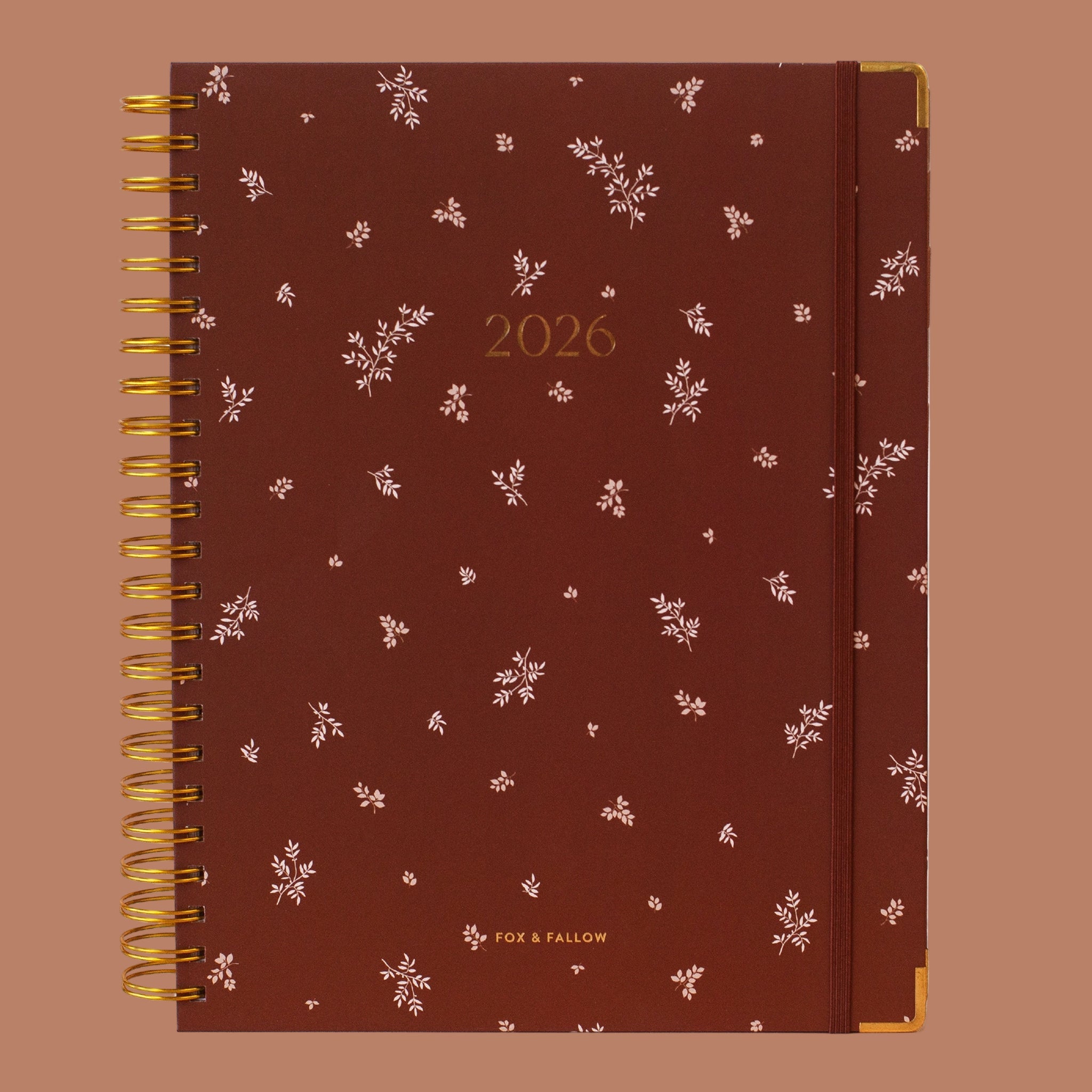 A dark brown planner with gold binding and gold foiled text that reads, "2026"