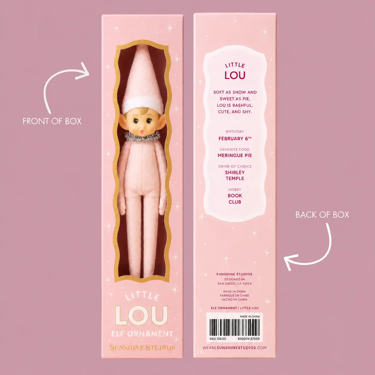 Pink retail packaging for the 'Little Lou' elf ornament by Sunshine Studios, showing both the front window box with the doll inside and the back of the box with product details, on a solid pink background with arrows indicating front and back views.