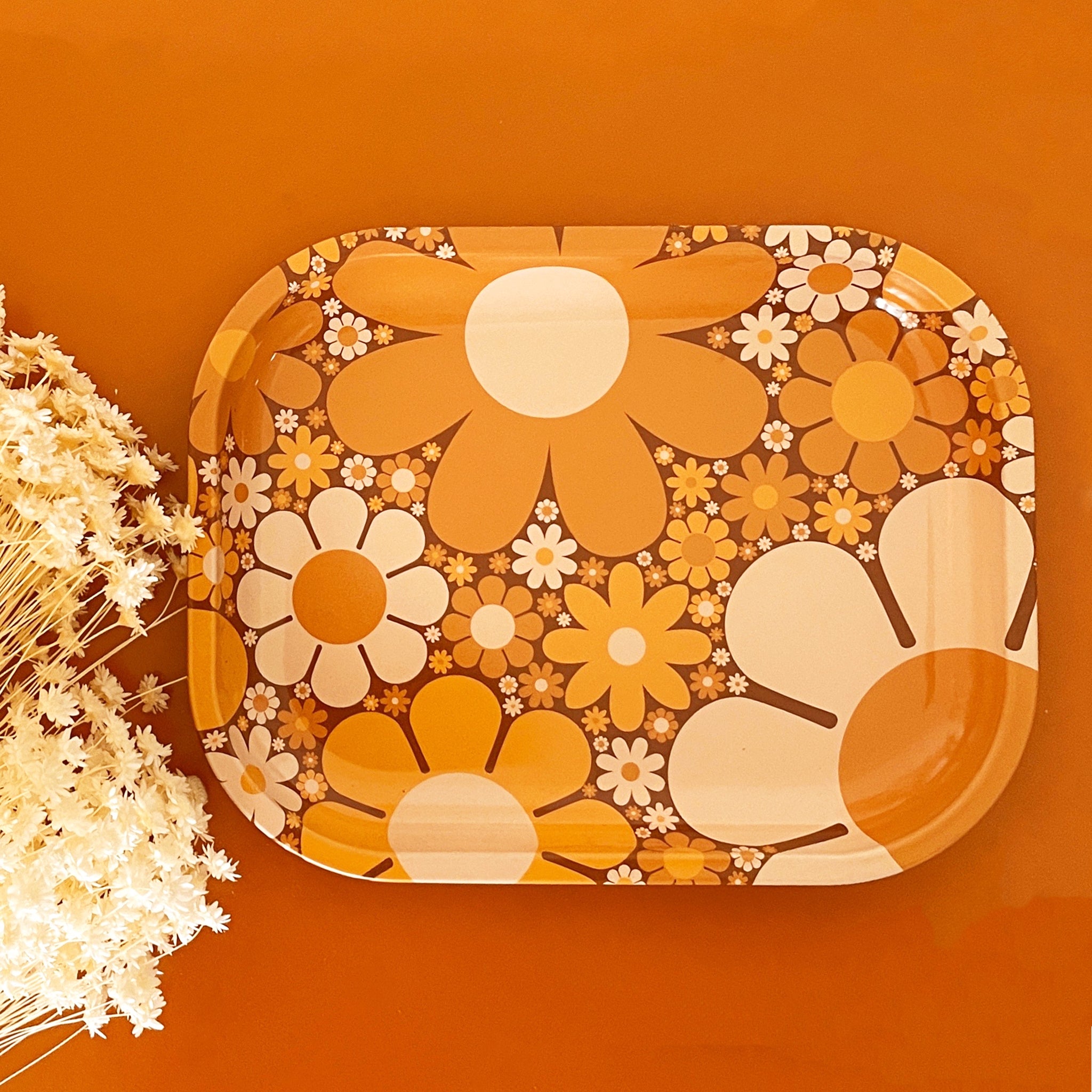 A metal tray perfect for rolling or all your favorite trinkets. It features a 70&#39;s inspired floral design with a variation of daisies in different shapes, sizes and colors.