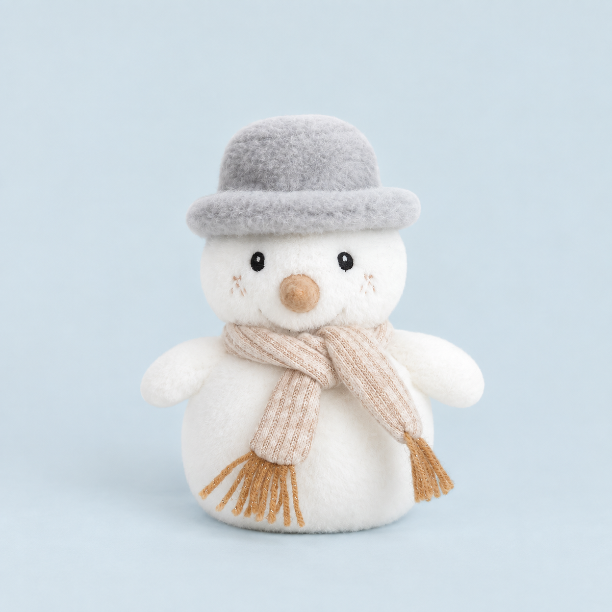 A white snowman shaped stuffed toy with a neutral scarf and a grey fuzzy top 