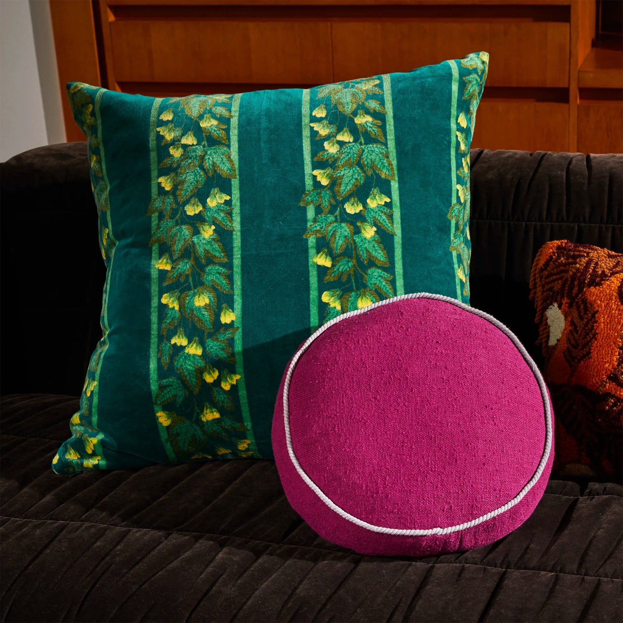 A round plum colored cushion. 