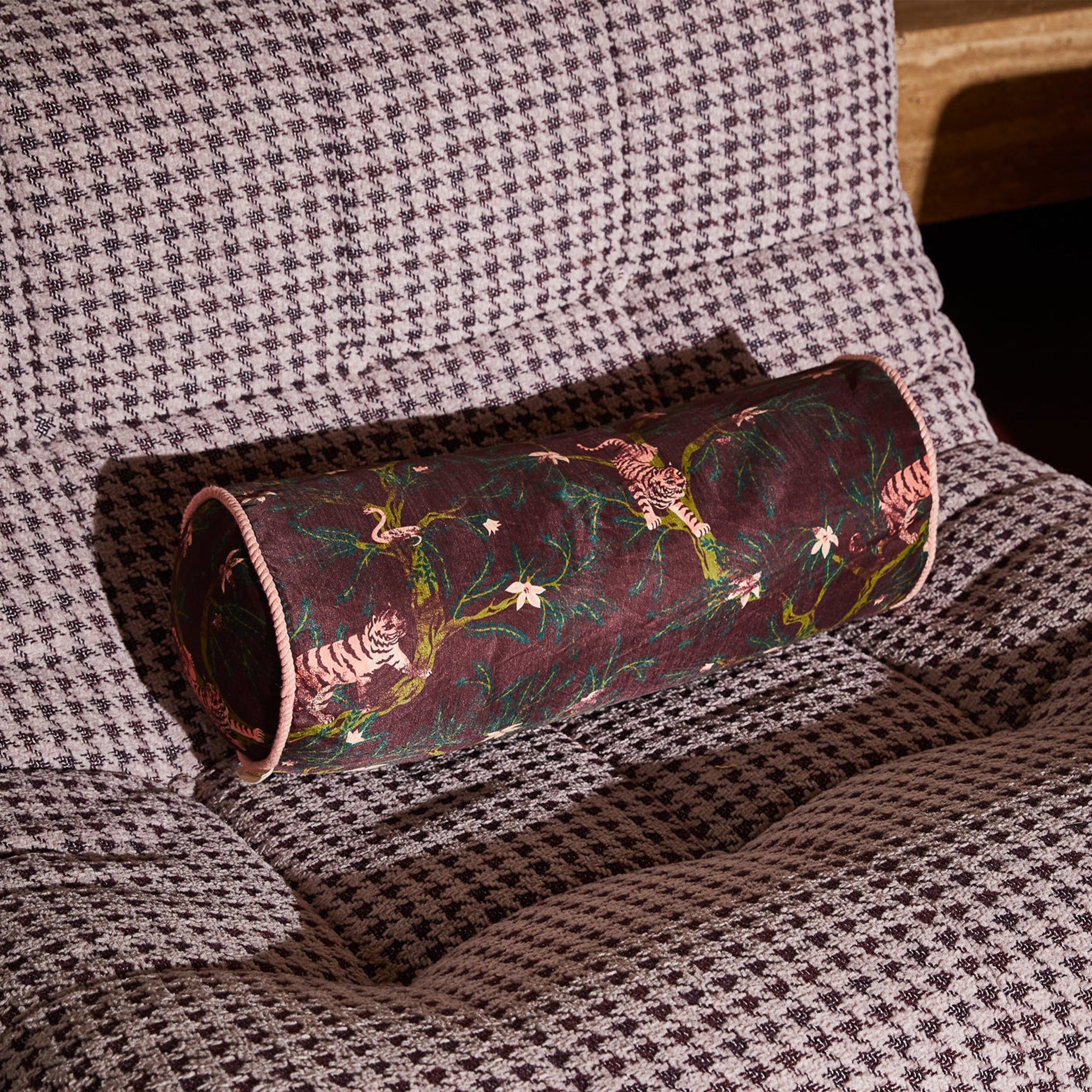 A bolster pillow with a tiger print. 