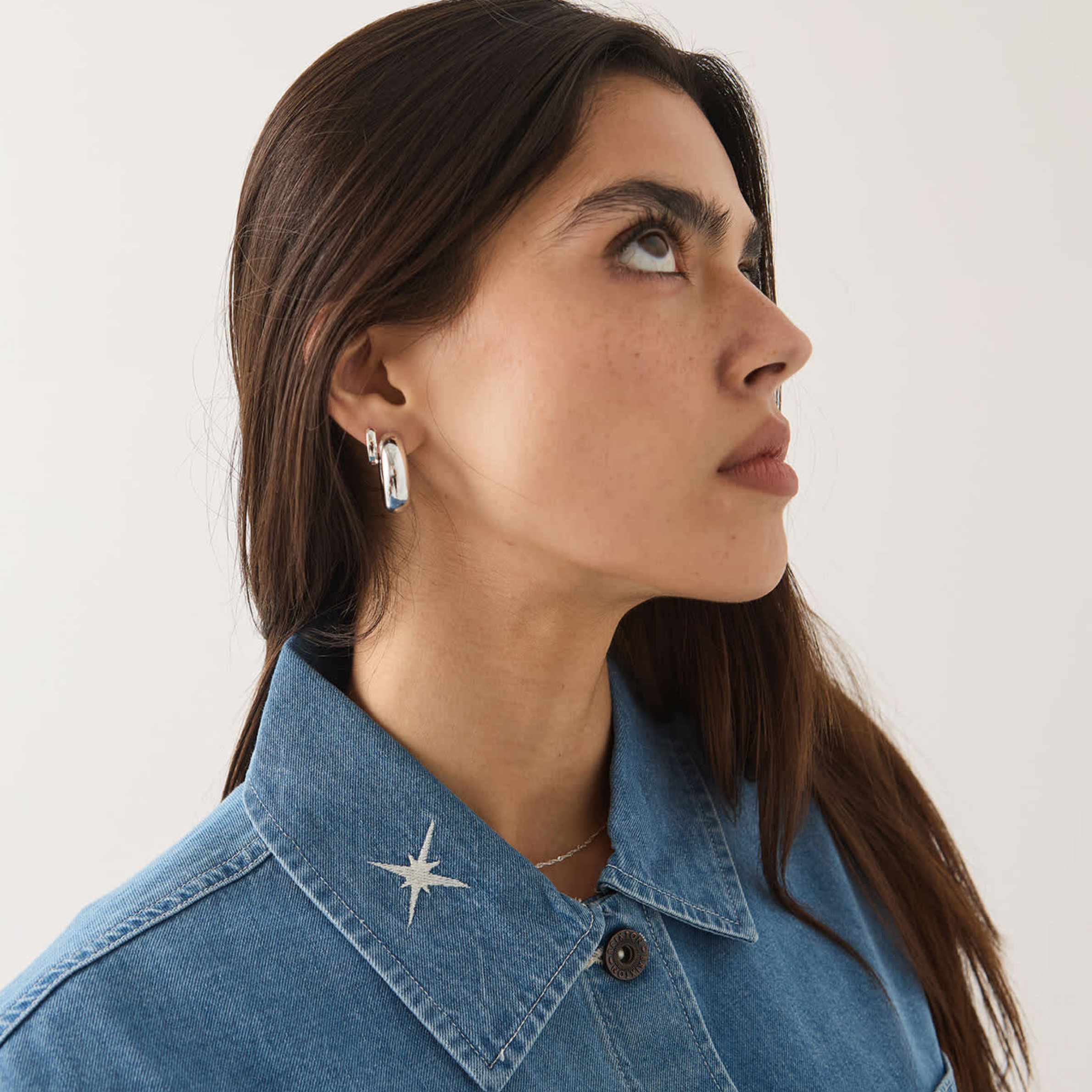 a light blue denim barn jacket with a horse and star embroidered design. 