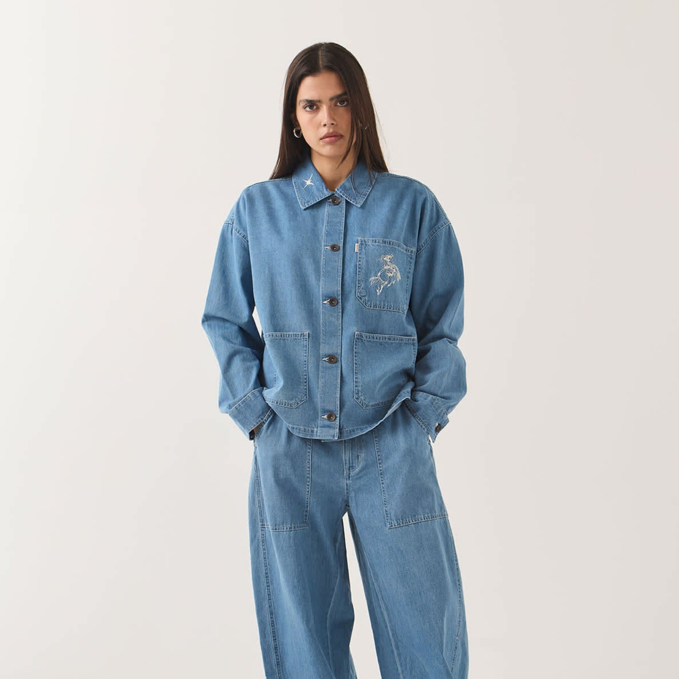 a light blue denim barn jacket with a horse and star embroidered design. 