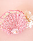 A pink beaded shell shaped pouch. 