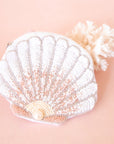 A white and pink beaded shell shaped pouch. 