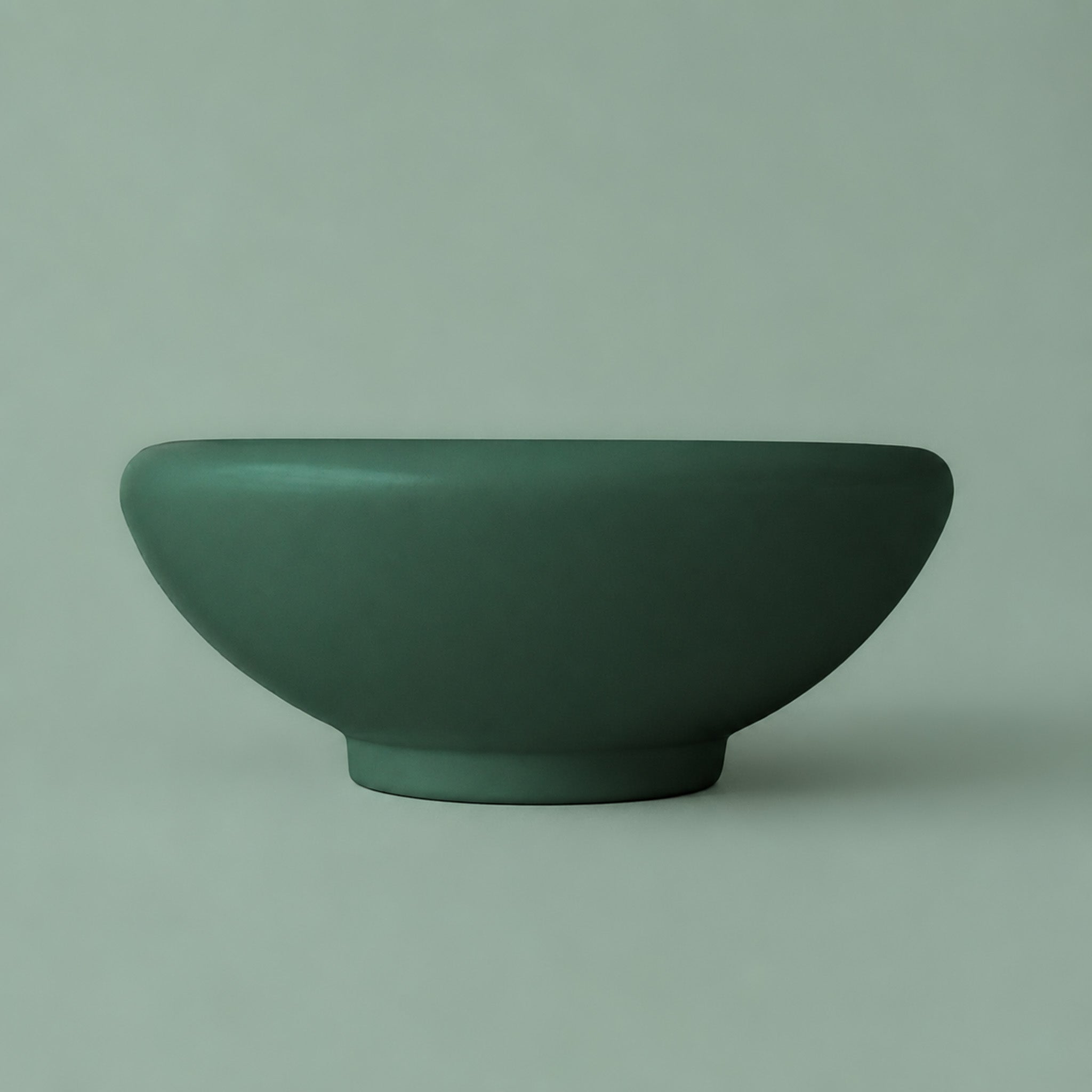 A low rounded ceramic pedestal bowl made of ceramic. 