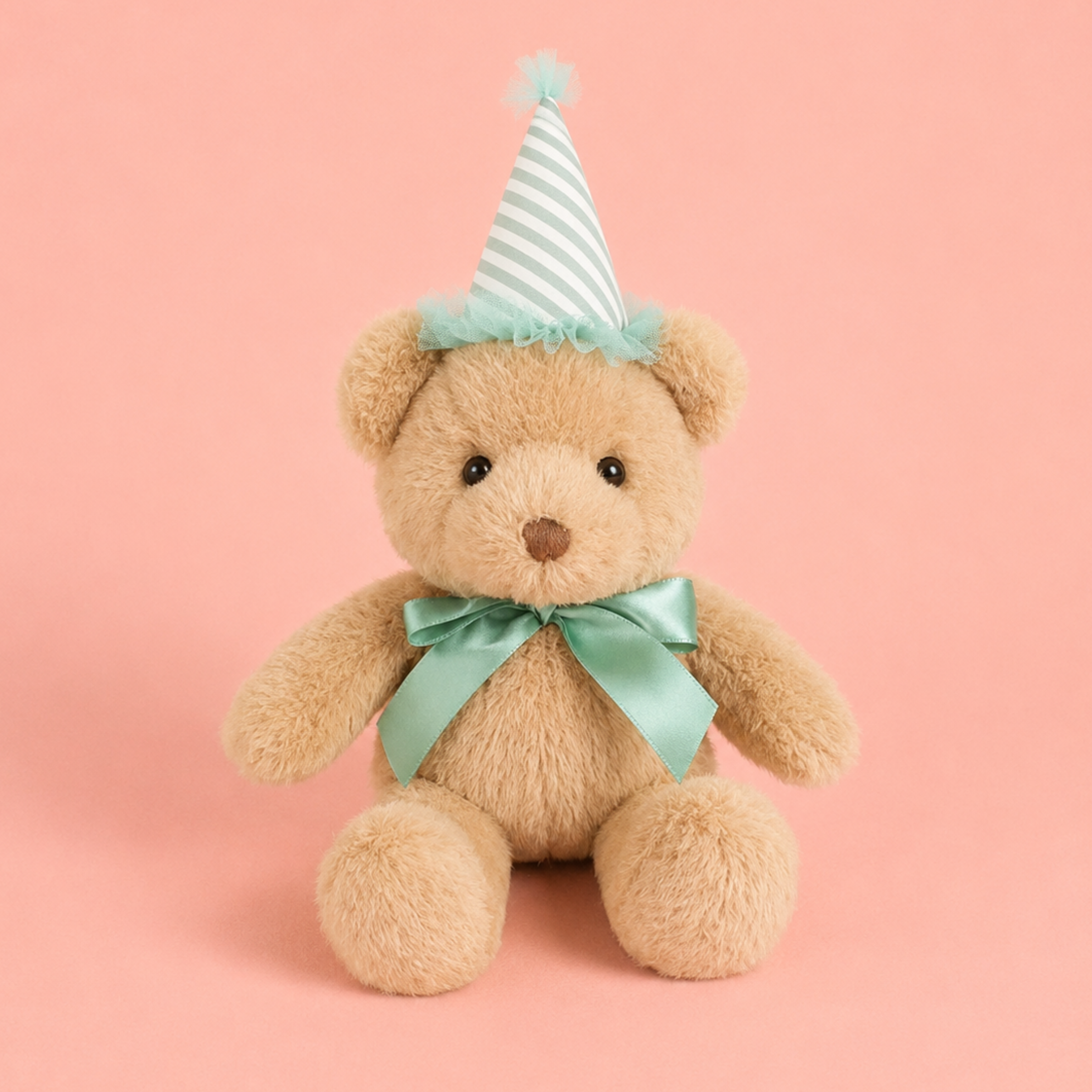 a bear stuffed animal toy wearing a greenish blue bow and birthday hat