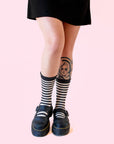 A pair of white and black striped crew socks.