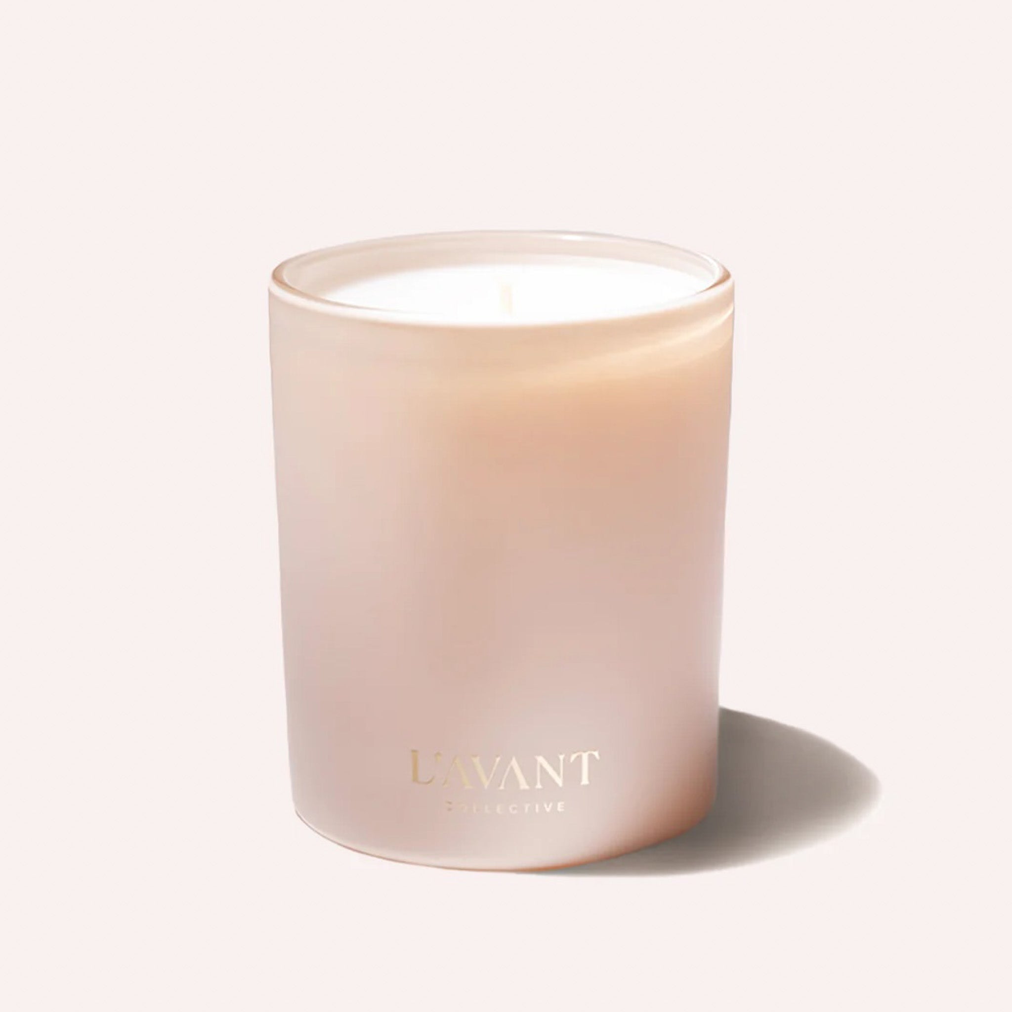 A pink candle on a light pink background.