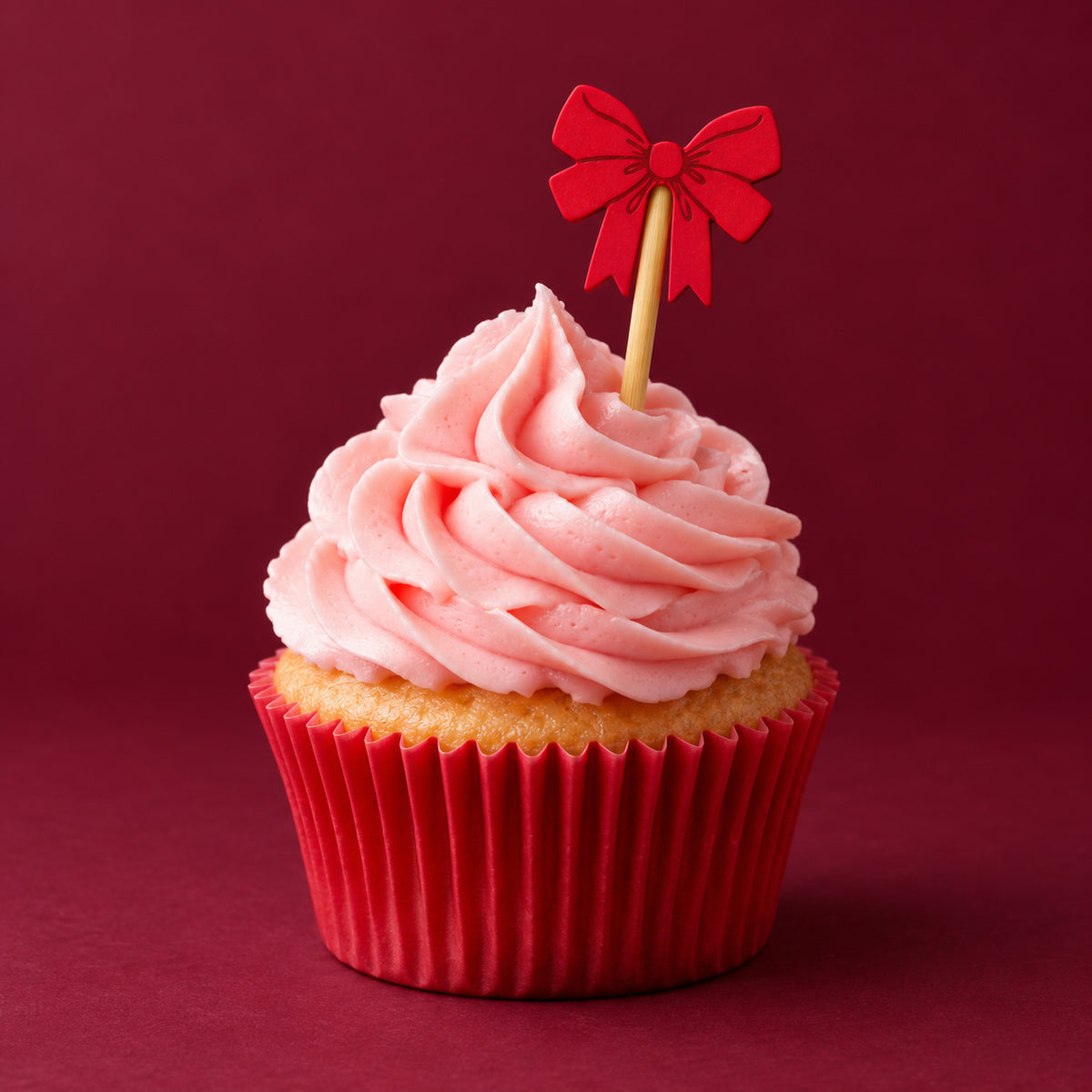 red bow shaped pick in a pink cupcake