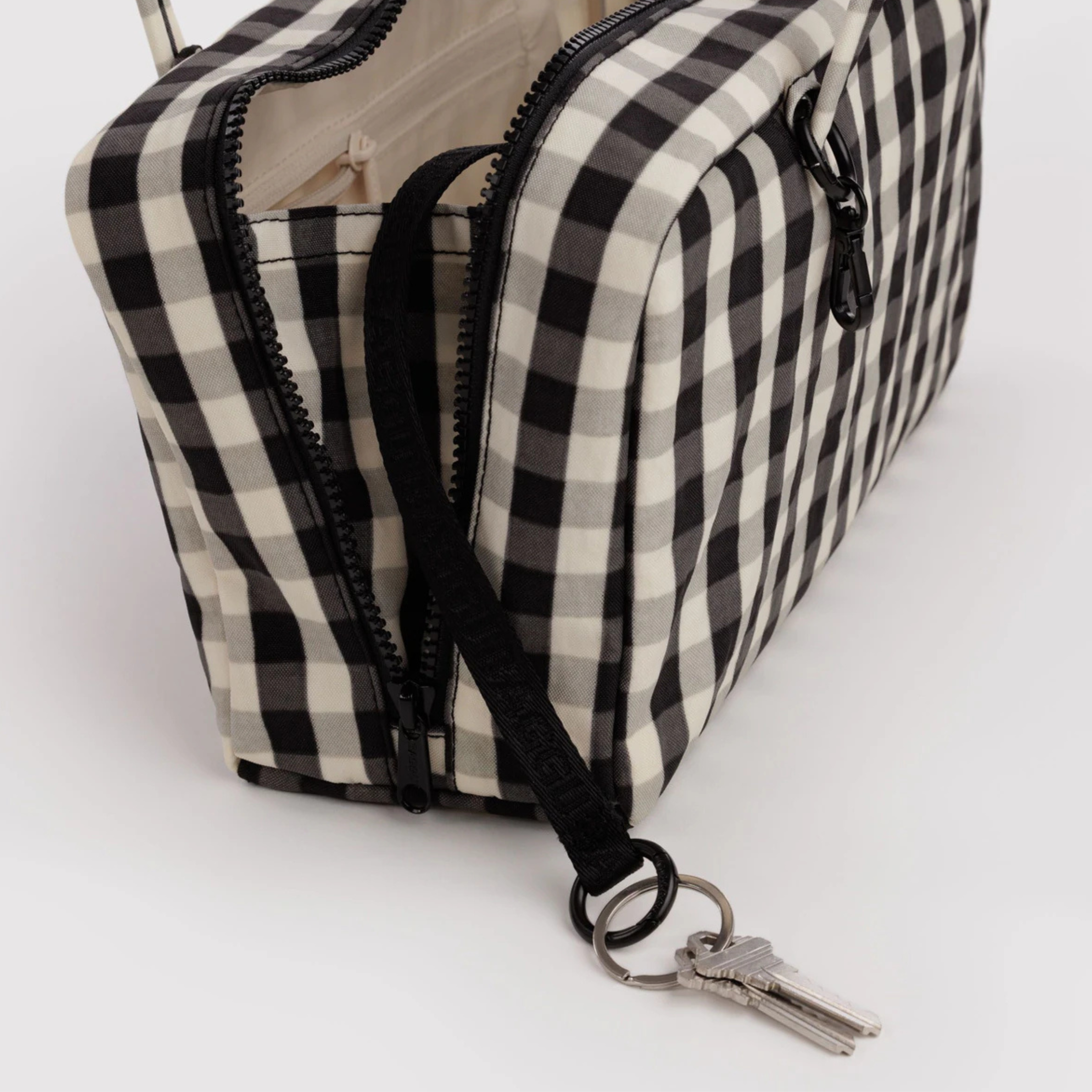 A cream and black gingham print shoulder bag.