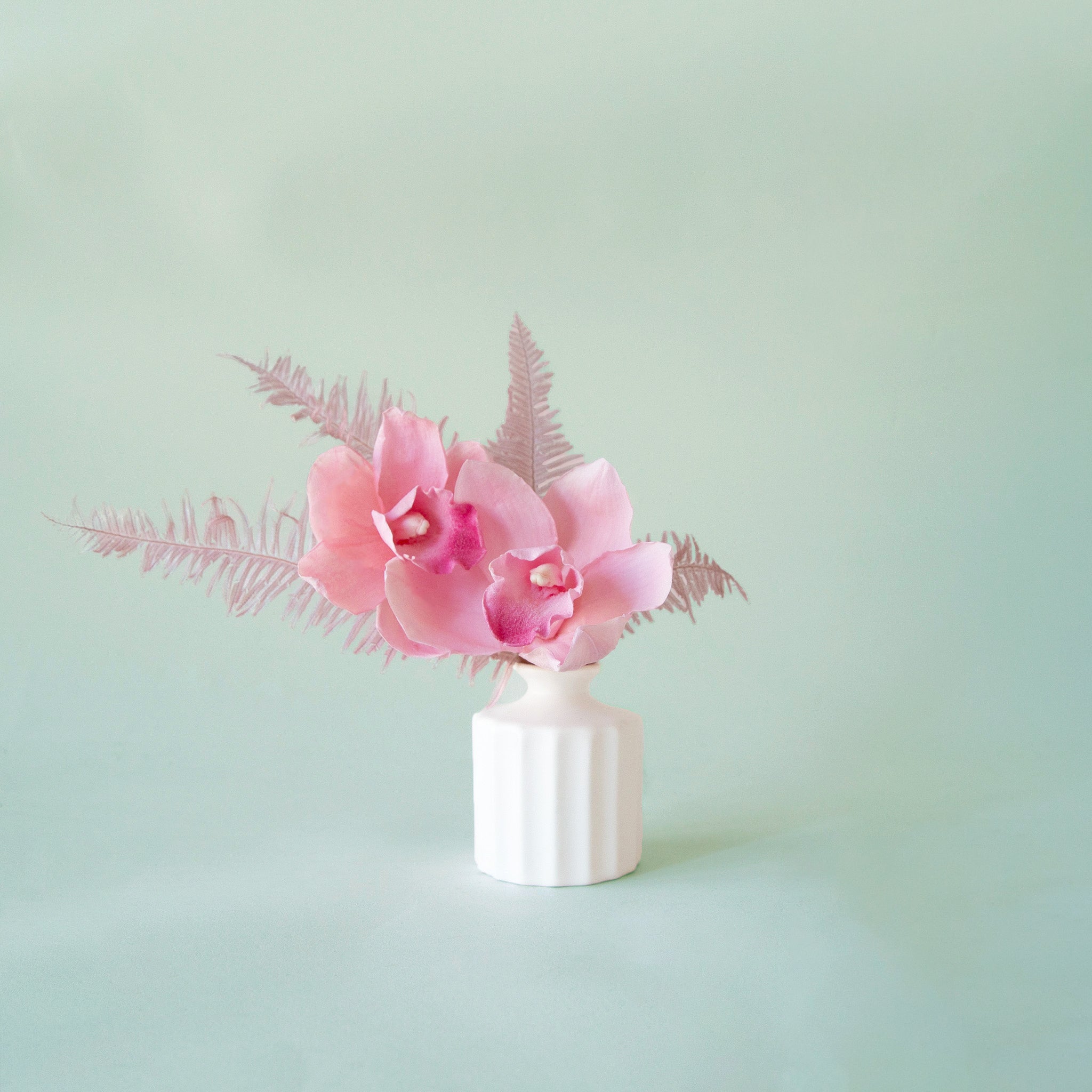 A white bud vase with a thick ribbed texture.