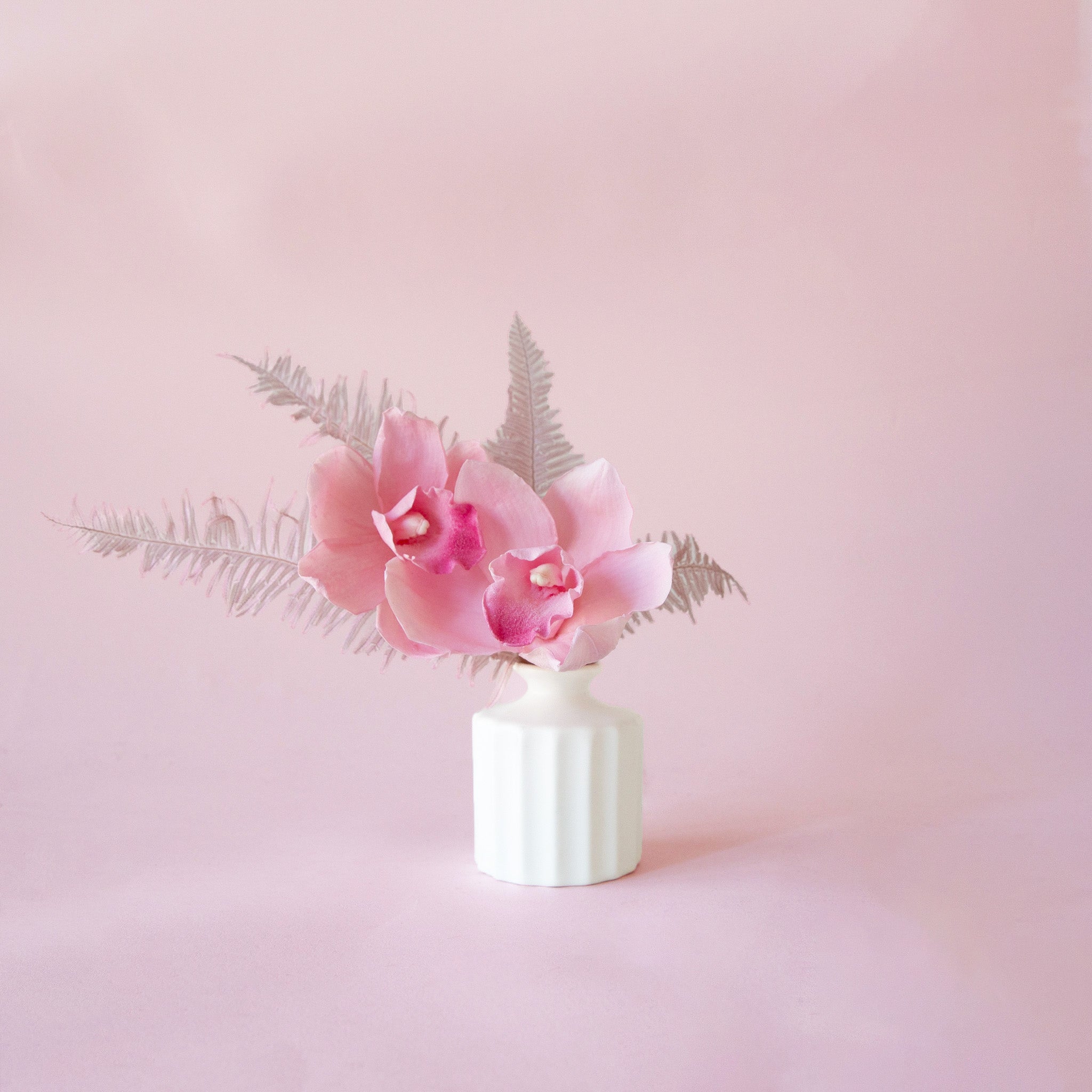 A white bud vase with a thick ribbed texture.