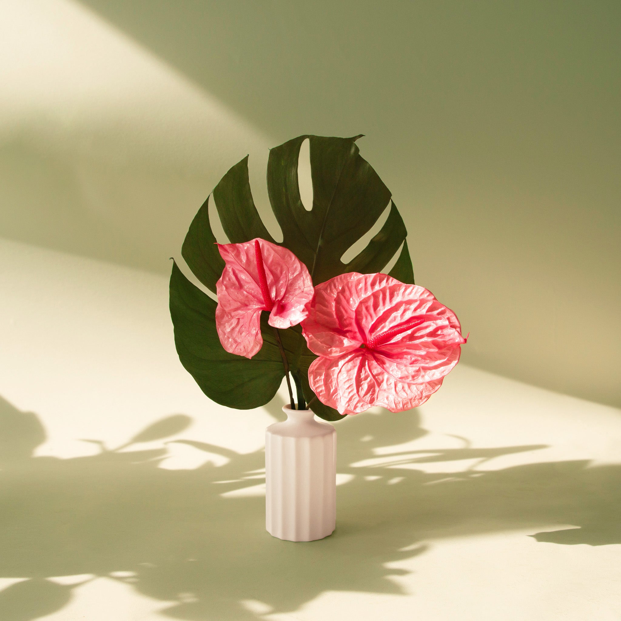 A white bud vase with a thick ribbed texture. 