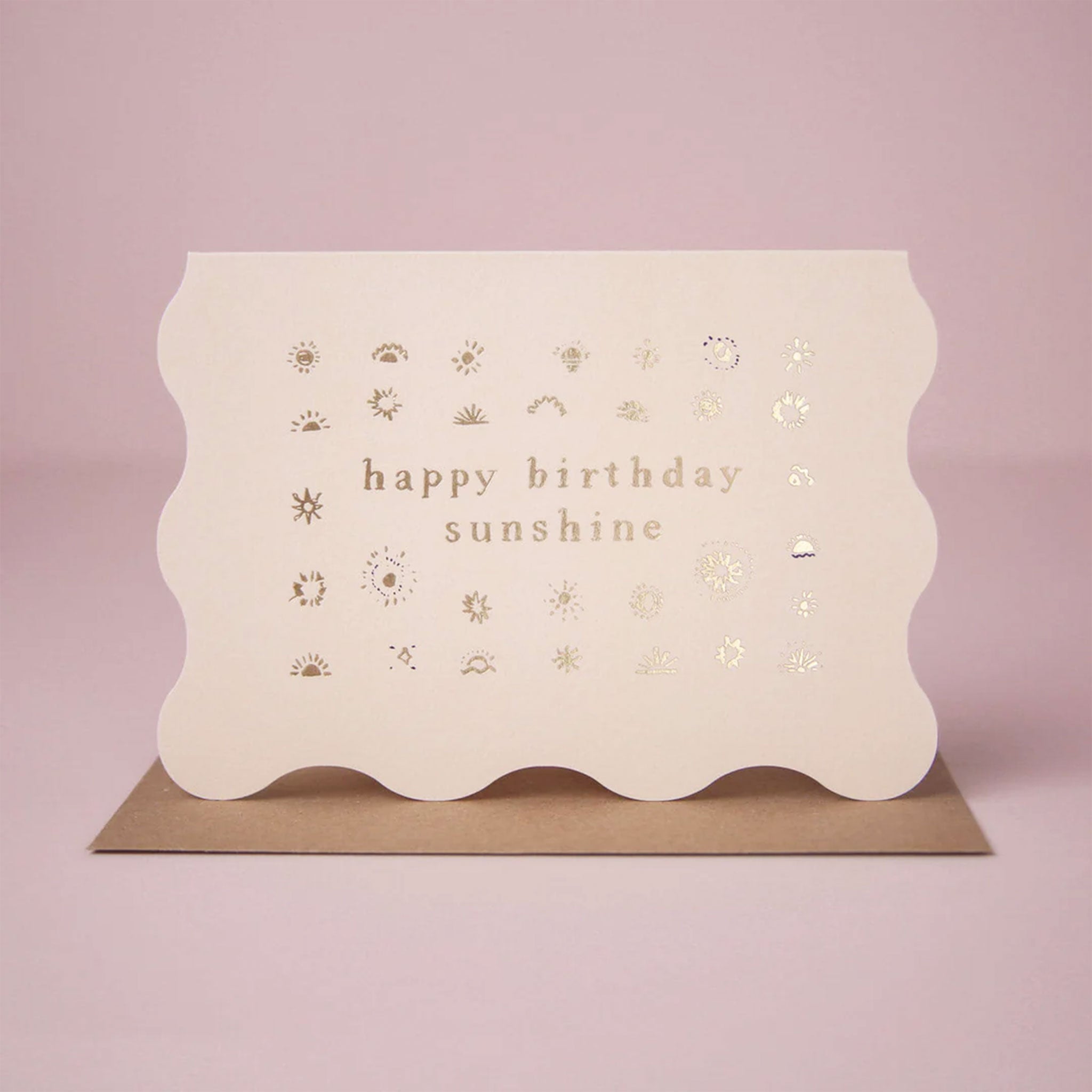 On a pink background is a wavy ivory card that reads, &quot;happy birthday sunshine&quot;. 