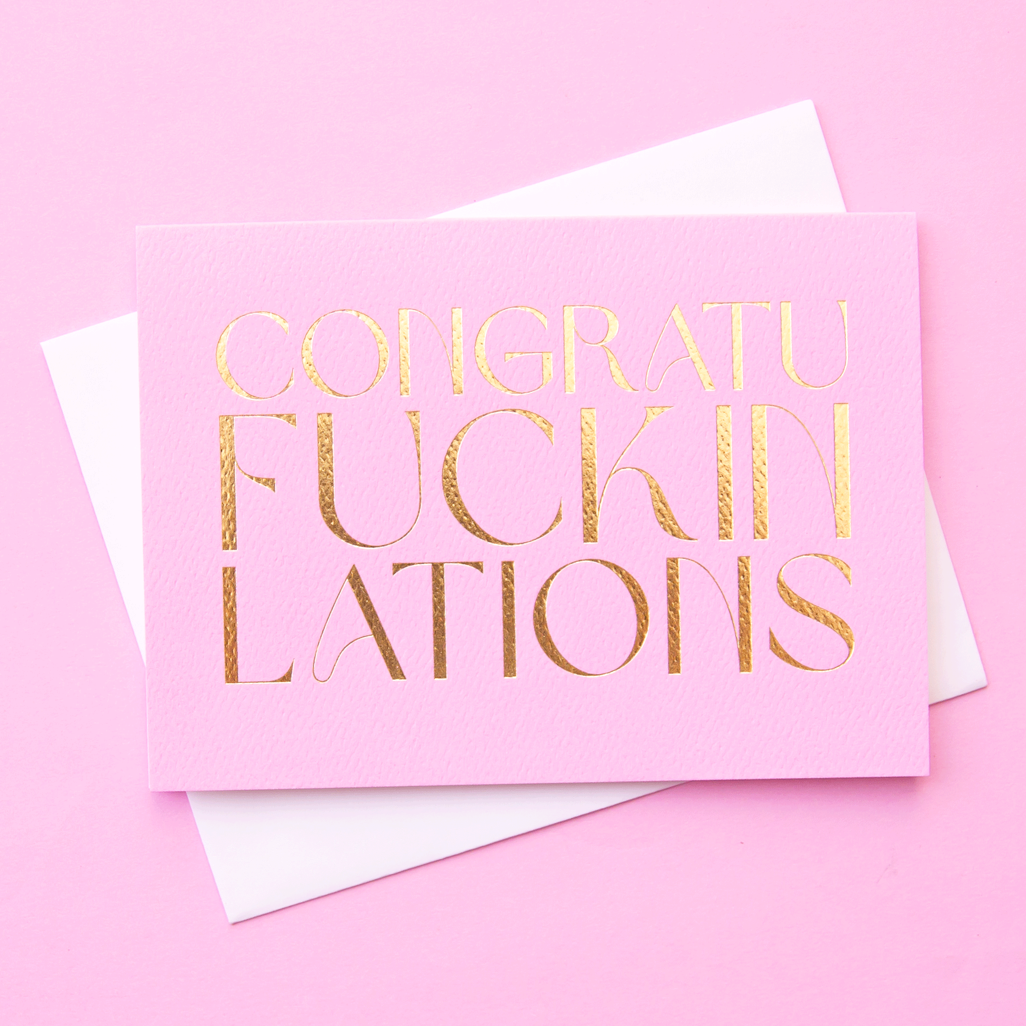 On the same colored background is a purple pink greeting card with gold foil text that reads, "Congraufuckinlations".