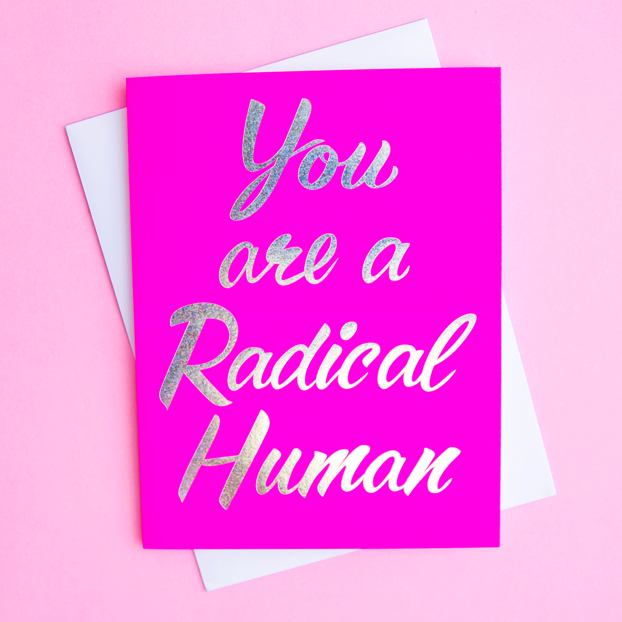 On a pink background is a hot pink card with foiled text that reads, &quot;You are a Radical Human&quot;. 