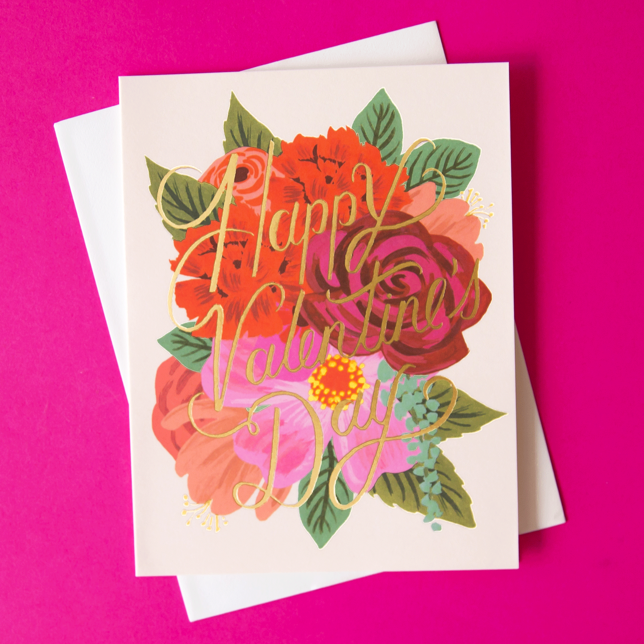 On a hot pink background is a light pink card with a red and pink illustration of a flower bouquet and gold text that reads, "Happy Valentine's Day".