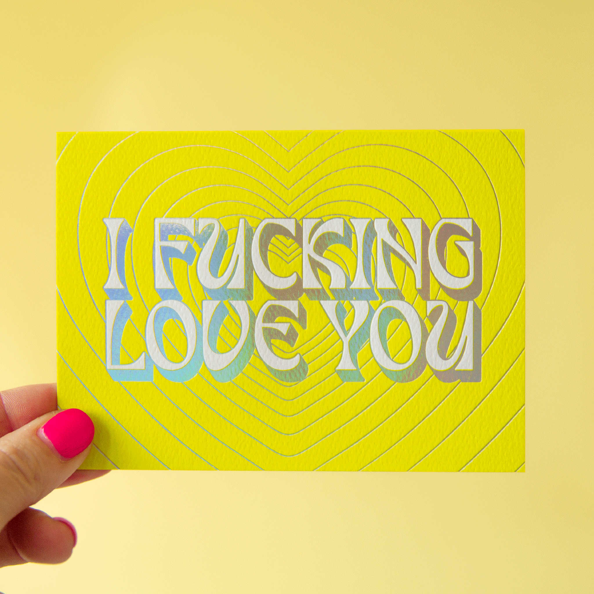 On a lime green background is a lime green card with silver heart shapes and text in the center that reads, "I Fucking Love You".