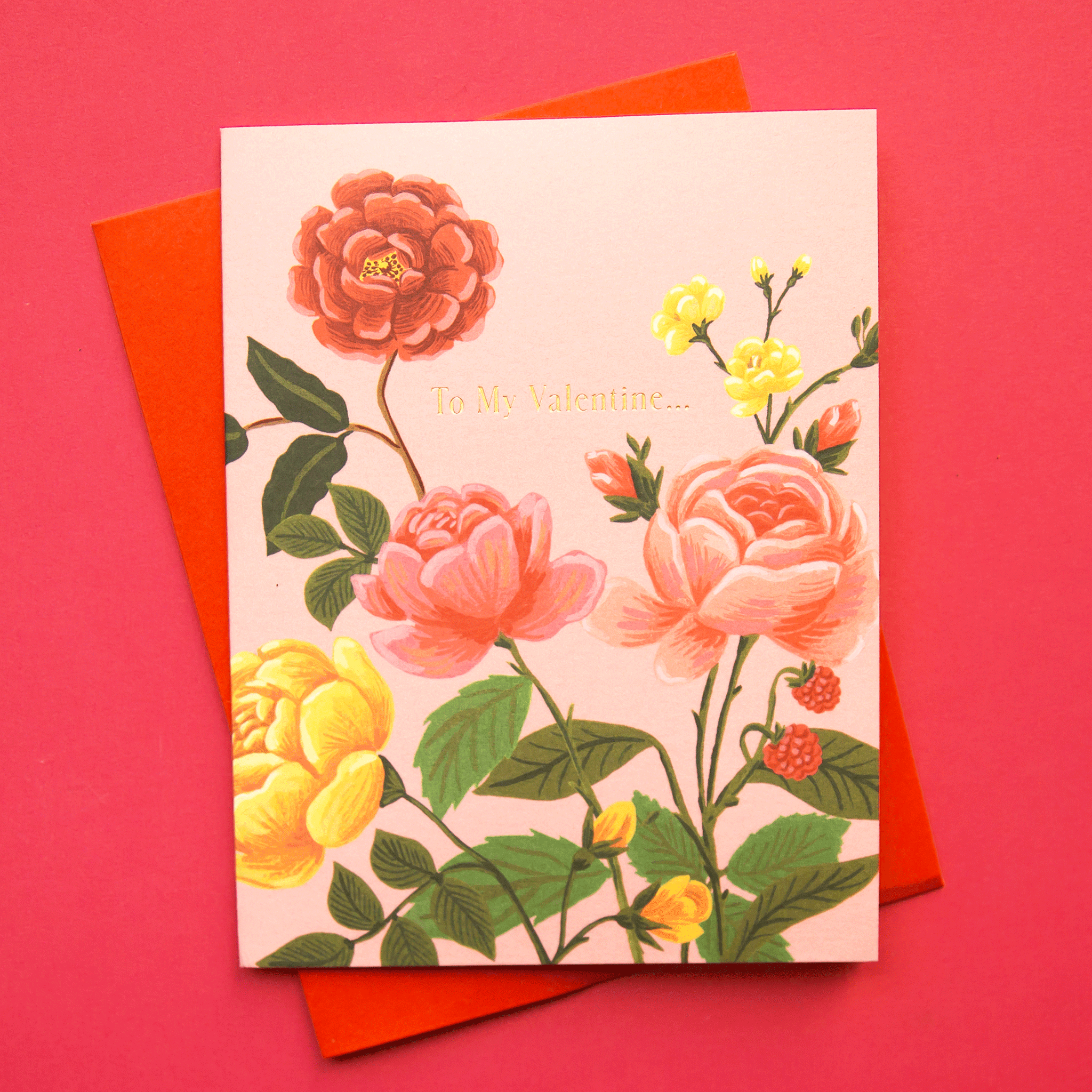 On a red background is a pink card with a floral print and text that reads, "To My Valentine..." as well as a coordinating red envelope.