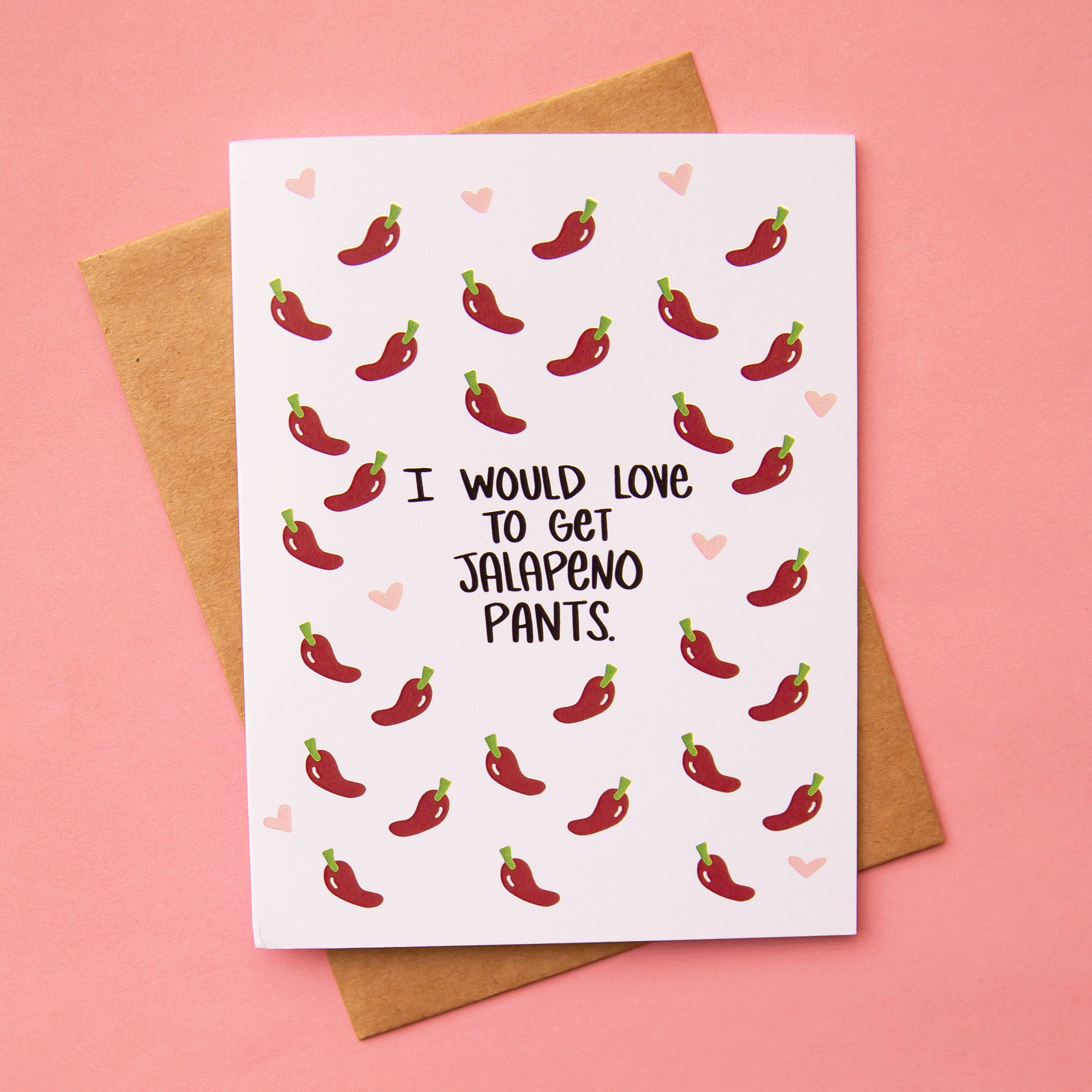 On a pink background is a white card with red peppers and black text in the center that reads, "I Would Love To Get Jalapeno Pants.".
