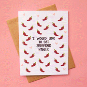 On a pink background is a white card with red peppers and black text in the center that reads, "I Would Love To Get Jalapeno Pants.".