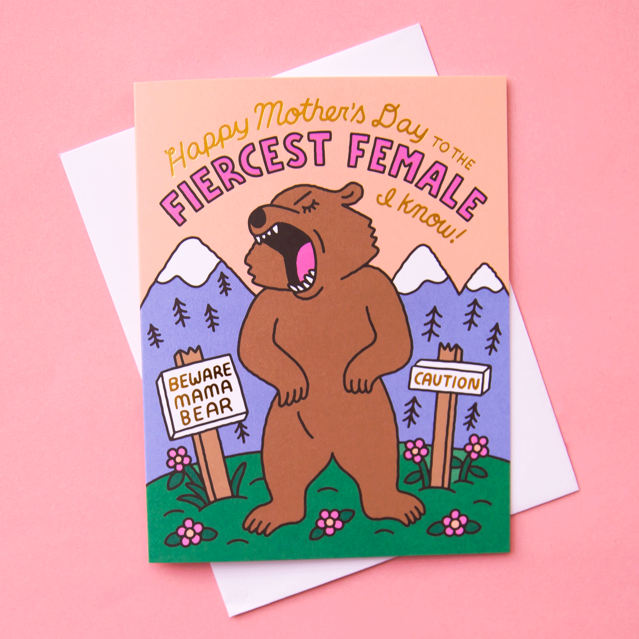 On a pink background is a card with a roaring mama bear illustrstion in front of a mountainous landscape and text above that reads, &quot;Happy Mother&#39;s Day To The Fiercest Female I Know!&quot; 