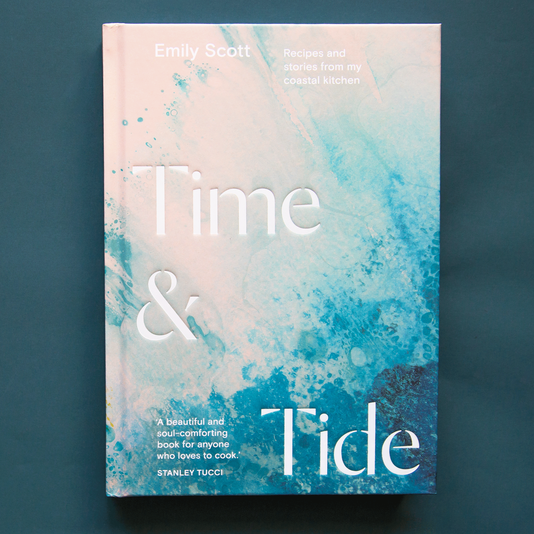 On a dark blue background is a blue and white ocean front cover of a book with the title reading "Time & Tide". 