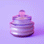 On a purple background is a purple glass jar candle with a coordinating lid. 