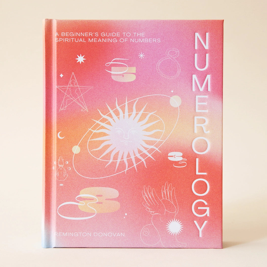 On a cream background is a hot pink and orange book with a white title running vertically down the right side that reads, "Numerology", "A Beginner's Guide To The Spiritual Meaning of Numbers". 