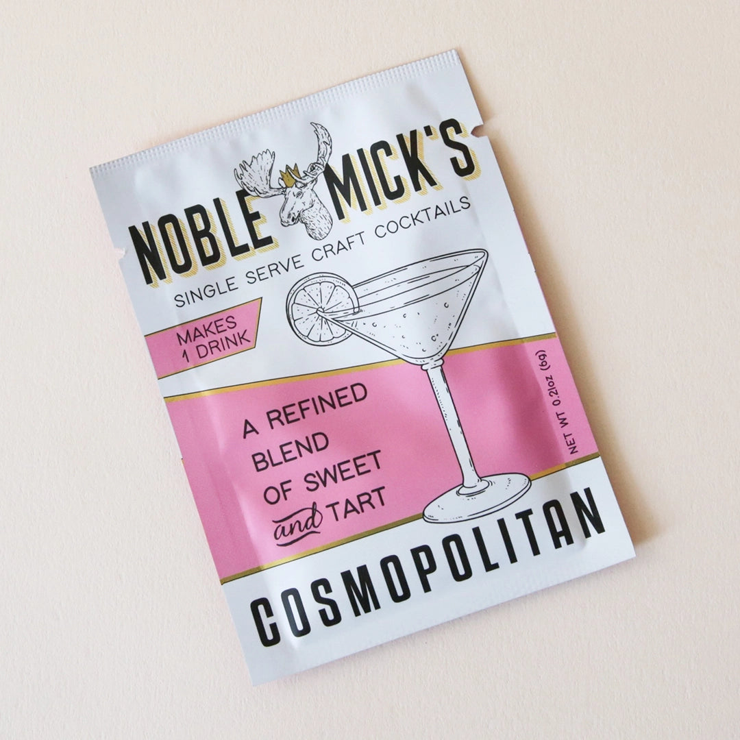 A pink and white packet of craft cocktail mix that says, "Noble Mick's Single Serve Craft Cocktails" along with a martini glass.
